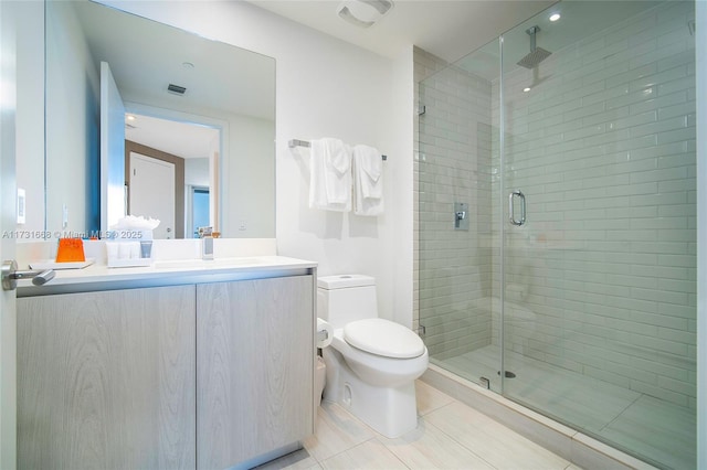 bathroom featuring vanity, toilet, tile patterned floors, and walk in shower