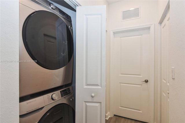 washroom featuring stacked washing maching and dryer and hardwood / wood-style floors