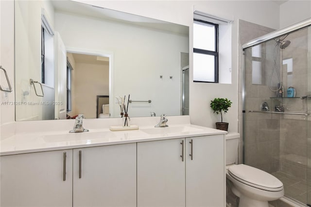 bathroom featuring vanity, an enclosed shower, and toilet