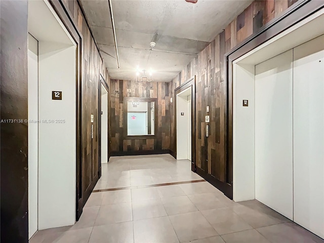 corridor featuring elevator and wood walls