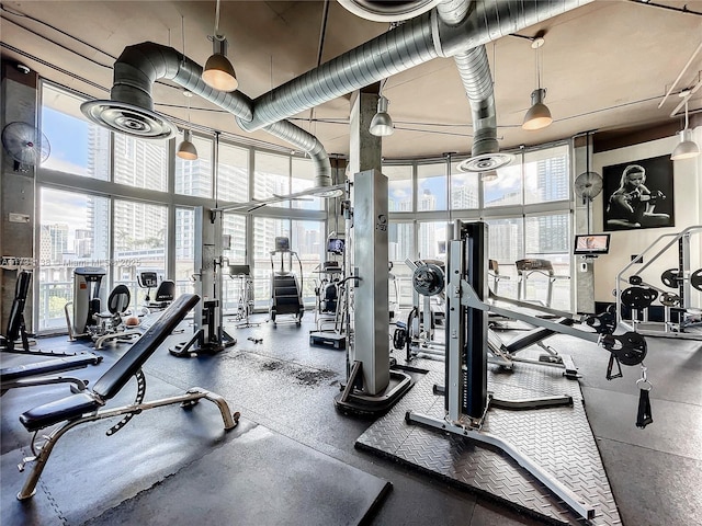 gym with a towering ceiling, plenty of natural light, and expansive windows