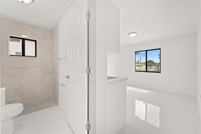 full bathroom featuring tile patterned flooring, a shower stall, toilet, and vanity