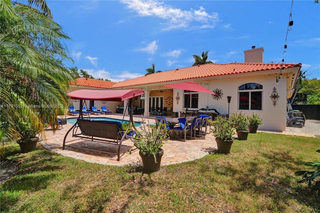 rear view of house with a yard, ceiling fan, and a patio area