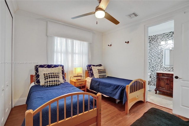 bedroom with wood-type flooring, ornamental molding, ceiling fan, and ensuite bathroom