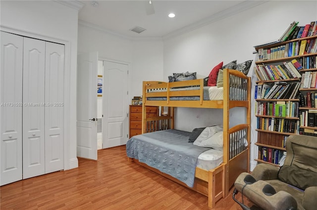 bedroom featuring crown molding, a closet, and light hardwood / wood-style flooring