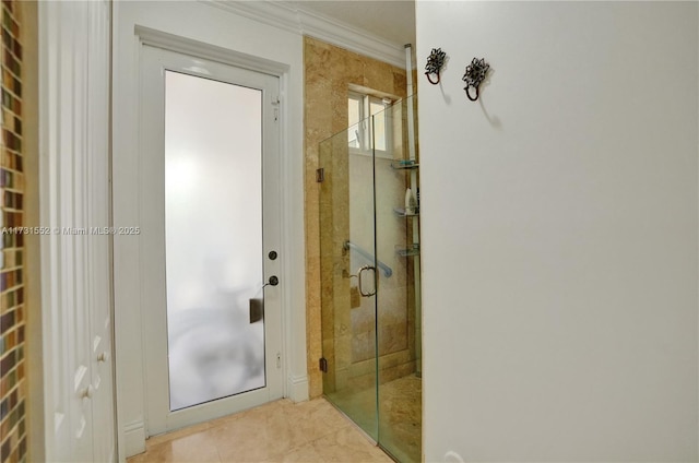 bathroom featuring tile patterned floors, ornamental molding, and a shower with door