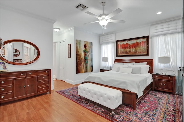 bedroom with crown molding, ceiling fan, multiple windows, and light wood-type flooring