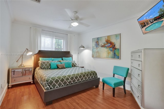 bedroom with wood-type flooring, ornamental molding, and ceiling fan