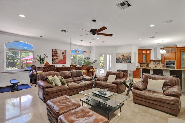 living room with crown molding, ceiling fan, and a healthy amount of sunlight