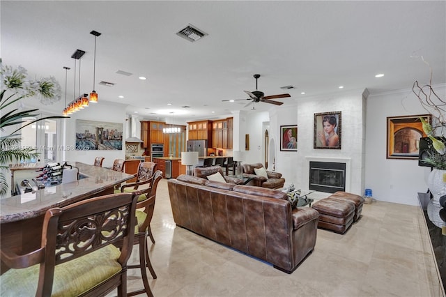 living room featuring crown molding, ceiling fan, and a fireplace