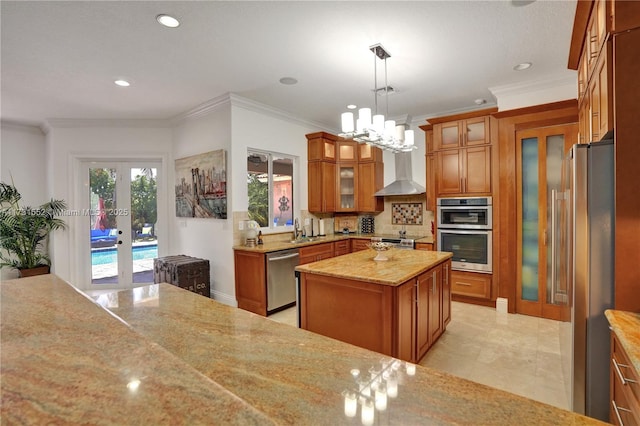 kitchen featuring french doors, light stone counters, hanging light fixtures, appliances with stainless steel finishes, and a kitchen island