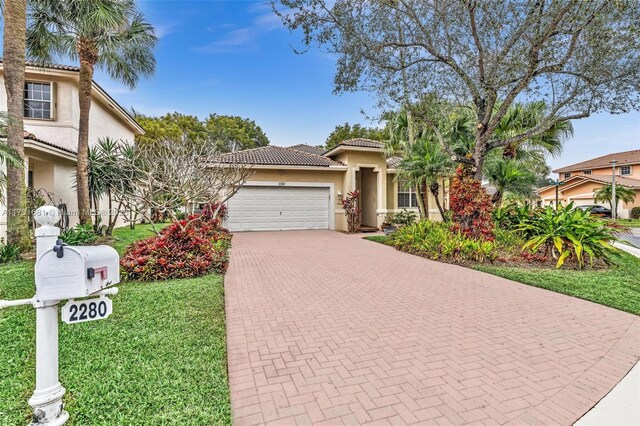 mediterranean / spanish-style house featuring a garage and a front yard