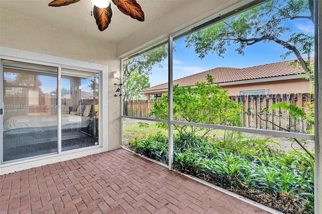 unfurnished sunroom with ceiling fan