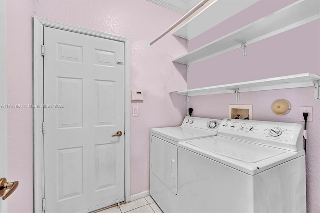 laundry room with light tile patterned flooring, washing machine and clothes dryer, and crown molding