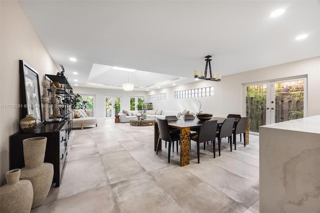 dining area featuring french doors and a raised ceiling