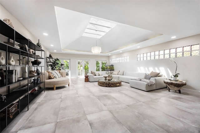 living room with a raised ceiling and a skylight