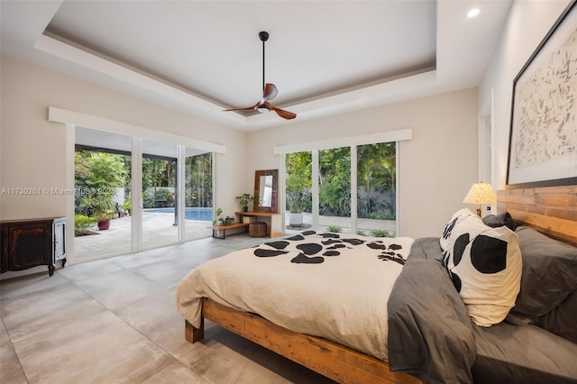 bedroom featuring a raised ceiling, access to outside, and ceiling fan