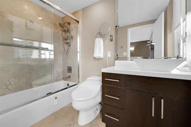 full bathroom featuring vanity, bath / shower combo with glass door, and toilet