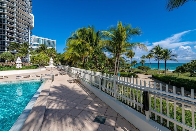 view of pool featuring a patio area and a water view