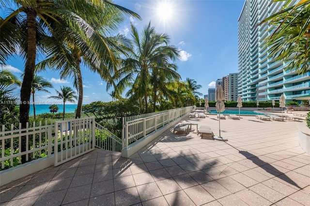 view of patio featuring a community pool and a water view