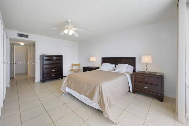 bedroom featuring light tile patterned floors, a textured ceiling, and ceiling fan