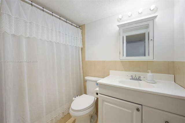 bathroom featuring tile walls, a shower with shower curtain, vanity, a textured ceiling, and toilet