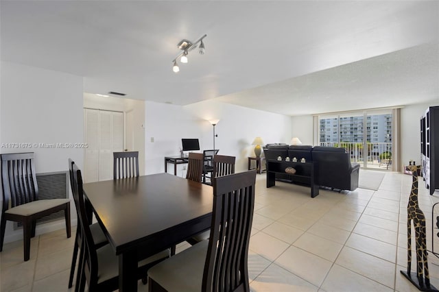 dining space with floor to ceiling windows and light tile patterned floors