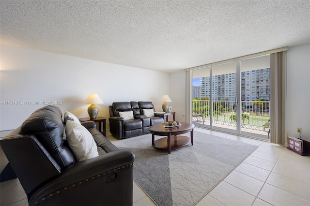 tiled living room featuring a wall of windows and a textured ceiling