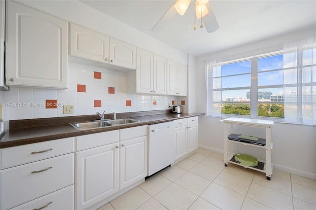 kitchen featuring sink, light tile patterned floors, white dishwasher, white cabinets, and backsplash