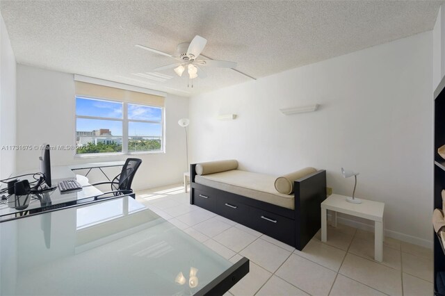 tiled bedroom featuring ceiling fan and a textured ceiling