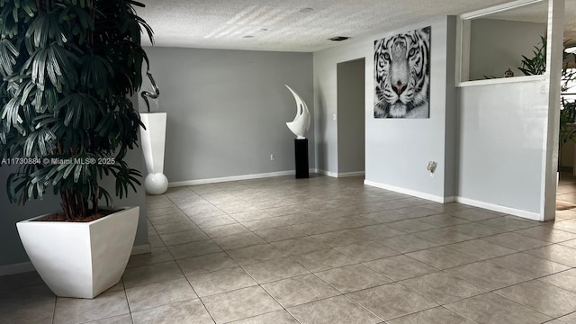 tiled spare room with a textured ceiling