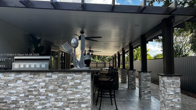 view of patio / terrace featuring ceiling fan and a bar