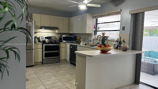 kitchen featuring light tile patterned flooring, sink, a textured ceiling, kitchen peninsula, and stainless steel appliances