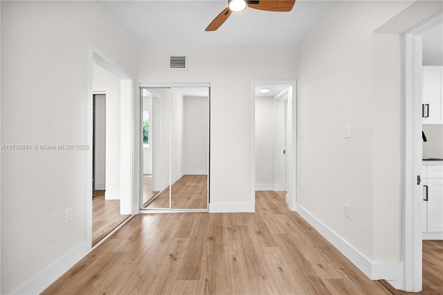 unfurnished bedroom with light wood-style flooring, visible vents, ceiling fan, and baseboards