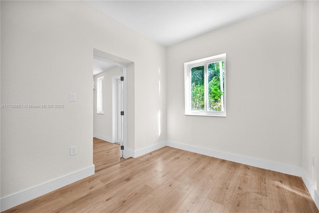 empty room with light wood-style floors and baseboards