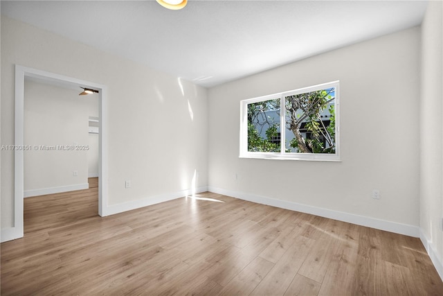 spare room with light wood-type flooring and baseboards