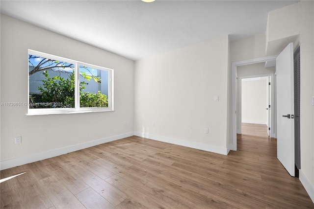 empty room featuring baseboards and wood finished floors