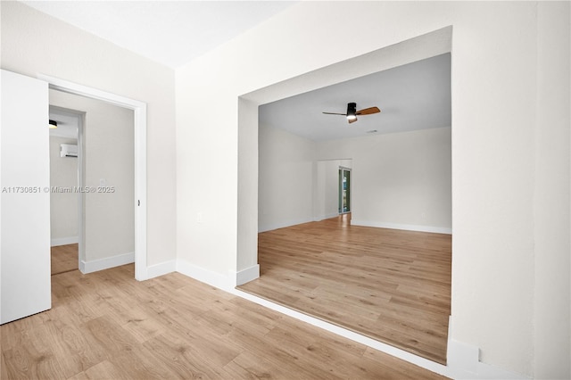 empty room with ceiling fan, baseboards, and wood finished floors