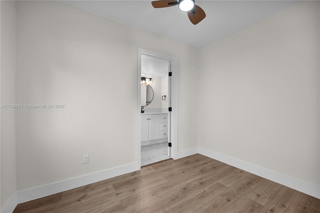 unfurnished bedroom featuring light hardwood / wood-style flooring, ceiling fan, and ensuite bathroom