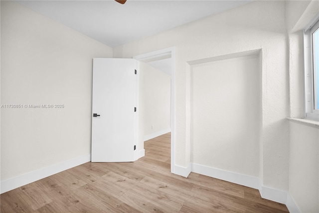 unfurnished room featuring vaulted ceiling and light hardwood / wood-style flooring