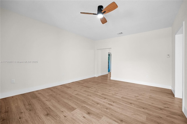 unfurnished room featuring light wood-type flooring, baseboards, visible vents, and a ceiling fan