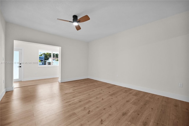 empty room with baseboards, ceiling fan, and light wood finished floors