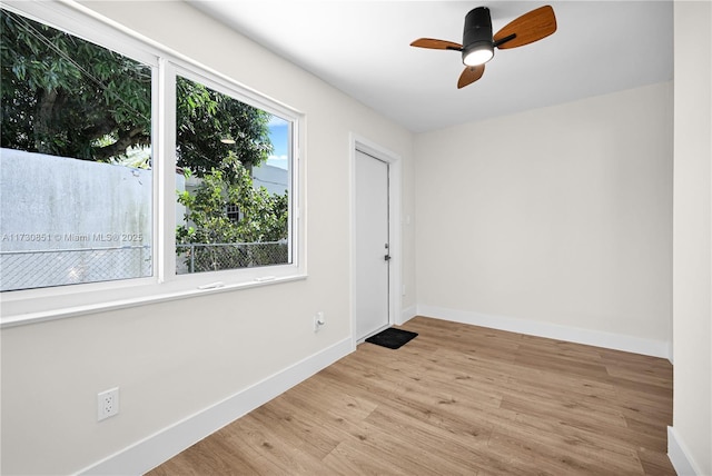 empty room with a ceiling fan, baseboards, and wood finished floors