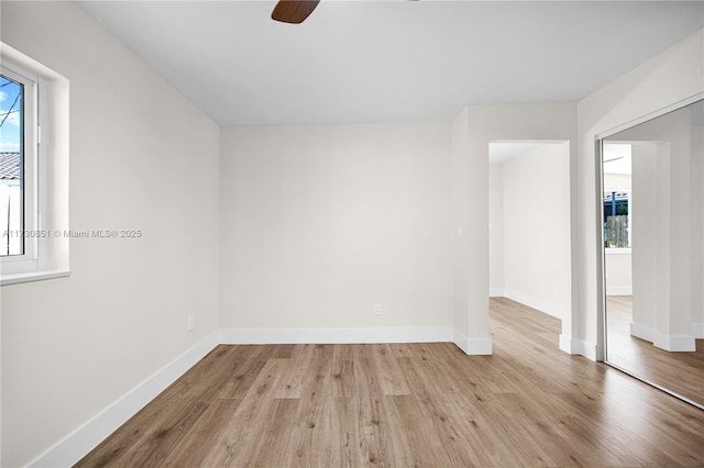 spare room with a ceiling fan, baseboards, and wood finished floors