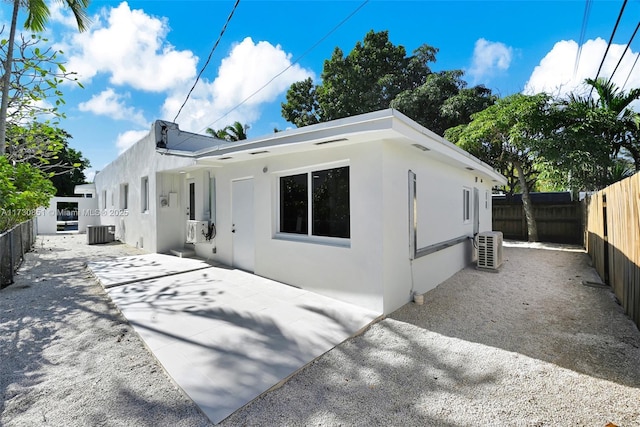 back of house with central air condition unit, a patio area, a fenced backyard, and stucco siding