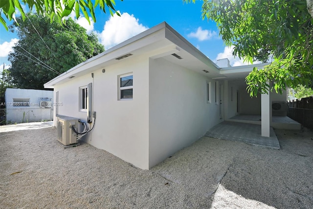 view of home's exterior featuring ac unit, fence, a patio, and stucco siding