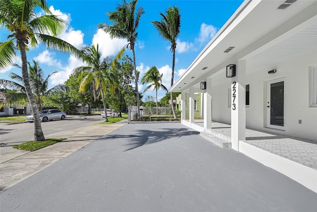 view of road featuring a gate and sidewalks