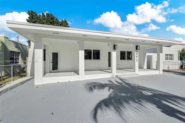 back of house with fence, a patio, and stucco siding