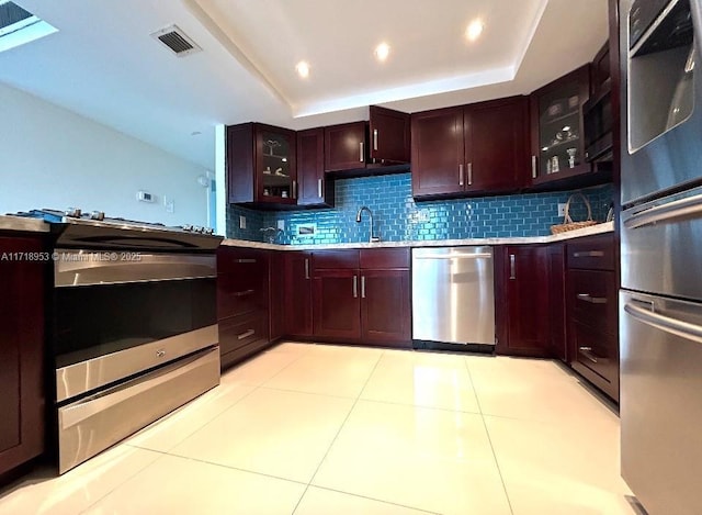 2030 S Ocean Dr Unit 506, Hallandale Beach, FL 33009 - kitchen featuring stainless steel appliances, light countertops, backsplash, glass insert cabinets, and a tray ceiling