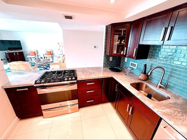 2030 S Ocean Dr Unit 506, Hallandale Beach, FL 33009 - kitchen featuring gas range, light stone countertops, backsplash, and light tile patterned floors
